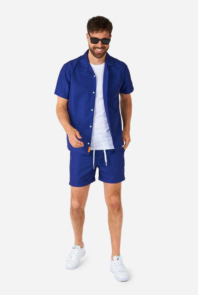 Man wearing dark blue summer set, consisting of shirt and shorts