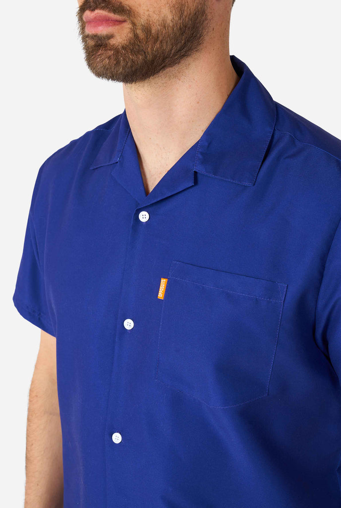 Man wearing dark blue summer set, consisting of shirt and shorts. Zoomed in at shirt