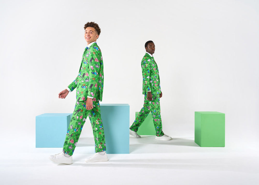 Two people wearing green Minecraft suits standing on colorful blocks against a white background