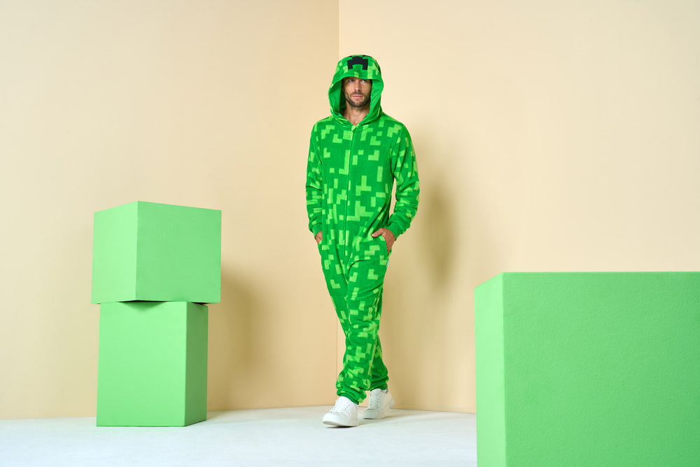 Image of man in Minecraft Onesie in corner of room with couple of blocks.