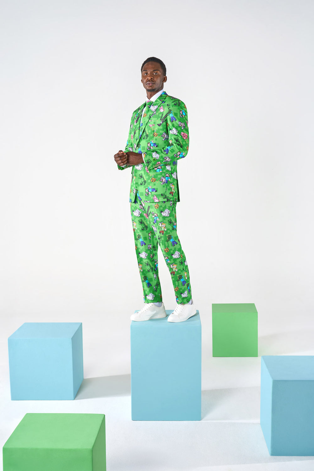 Image of man in Minecraft suit in a room with couple of blocks and standing on a block.