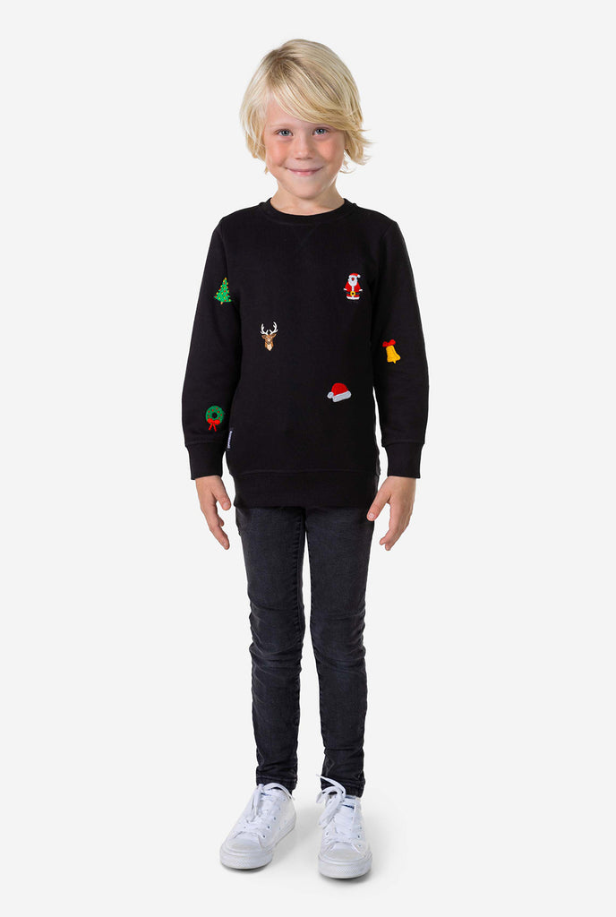Kid wearing black Christmas sweater with Christmas icons