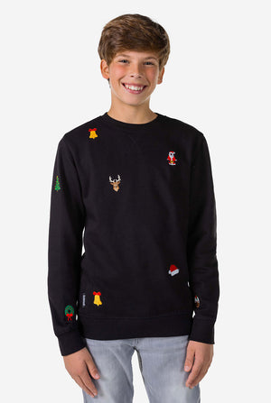 Teen wearing black Christmas sweater with Christmas icons
