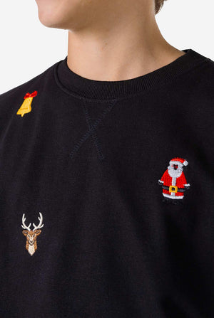 Teen wearing black Christmas sweater with Christmas icons