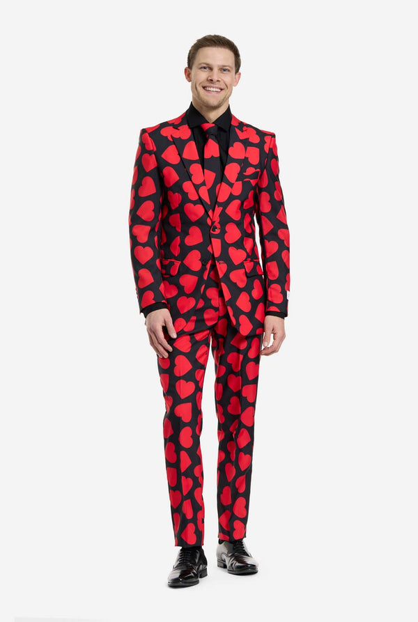 Man wearing a red heart-patterned suit on a white background