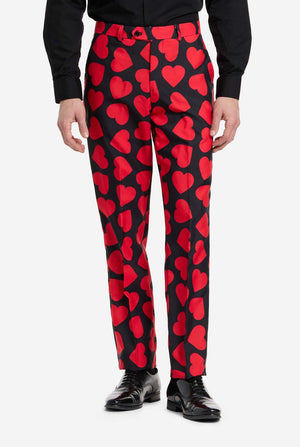 Red heart-patterned pants worn by a person on a white background