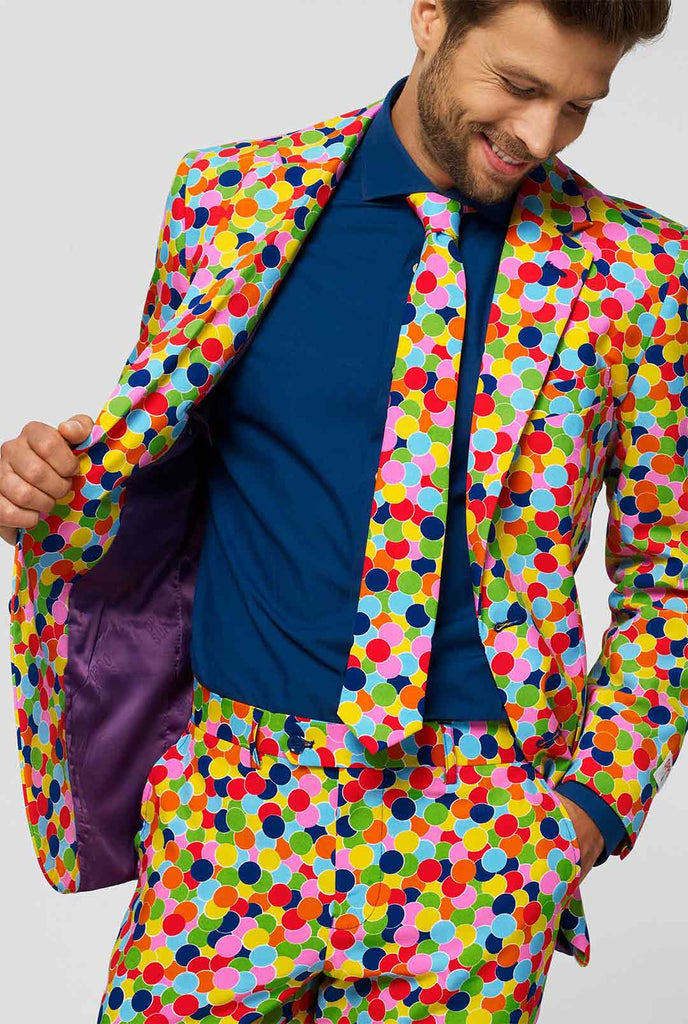 Man wearing men's suit with confetti print and blue dress shirt
