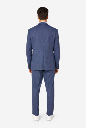 A men wearing a navy and blue checkered suit with a white dress shirt. The suit has a modern fit with two buttons and flap pockets. He stands against a plain white background. View from the back