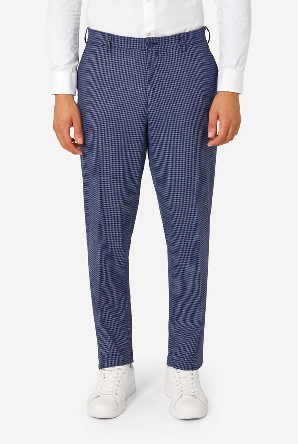 A men wearing a navy and blue checkered suit with a white dress shirt. The suit has a modern fit with two buttons and flap pockets. He stands against a plain white background. Close up of the pants