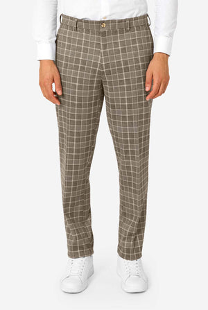 A men wearing a tan checkered suit with a white dress shirt. The suit has a modern fit with two buttons and flap pockets. He stands against a plain white background. Close up of the pants