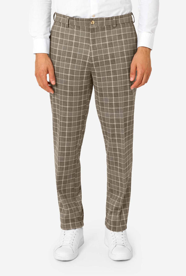 A men wearing a tan checkered suit with a white dress shirt. The suit has a modern fit with two buttons and flap pockets. He stands against a plain white background. Close up of the pants