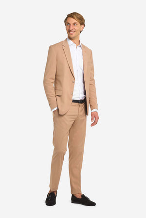 Image with light grey background and man wearing Dark Sand men’s suit and white shirt. Suits consists of blazer and pants. Full body image.