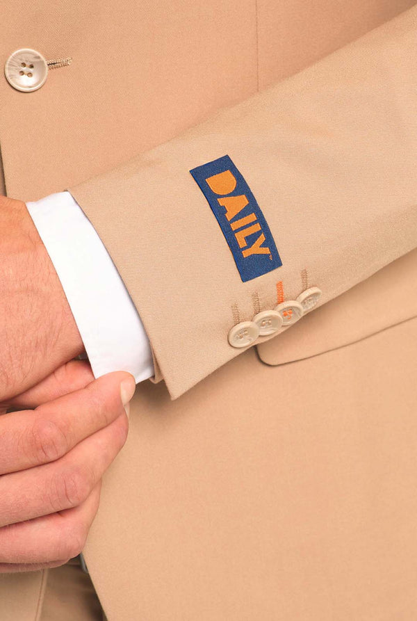 Image with light grey background and man wearing Dark Sand men’s suit and white shirt. Suits consists of blazer and pants. Focused on the sleeves.