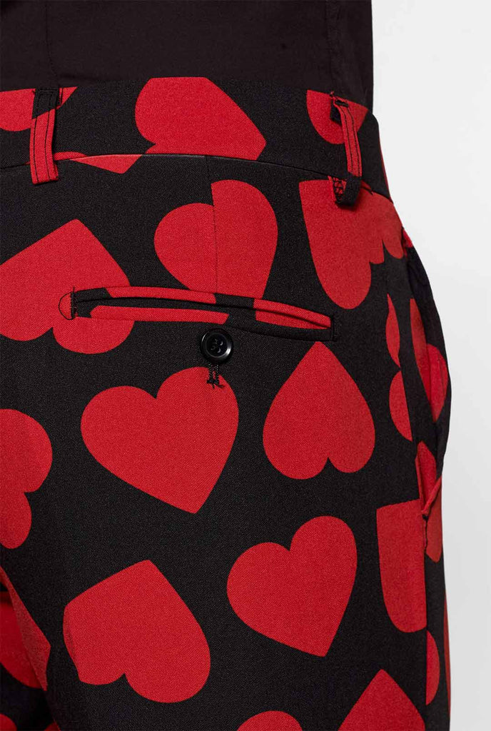 Man wearing black suit with red hearts print