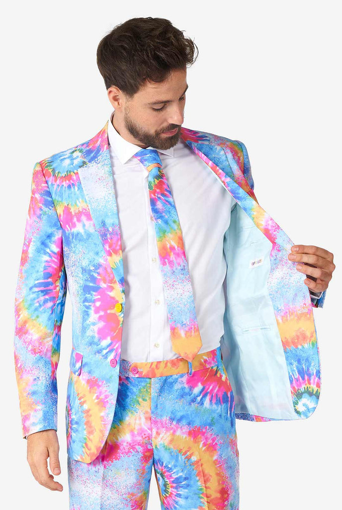 Man wearing pride men's suit with colorful tie dye rainbow print 