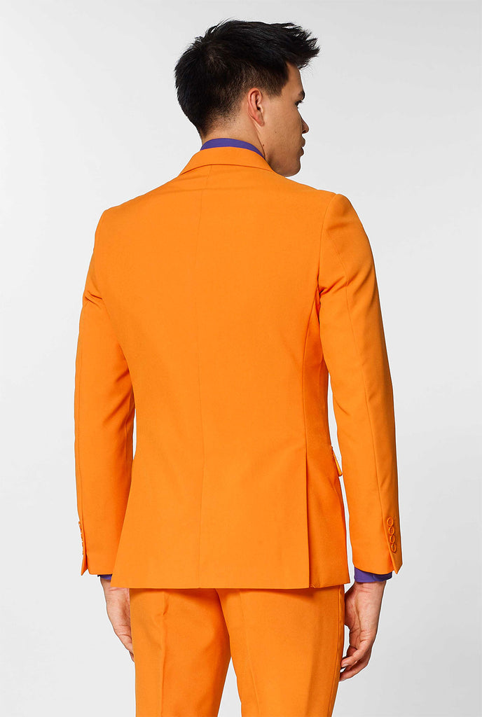 Man wearing orange men's suit with purple dress shirt