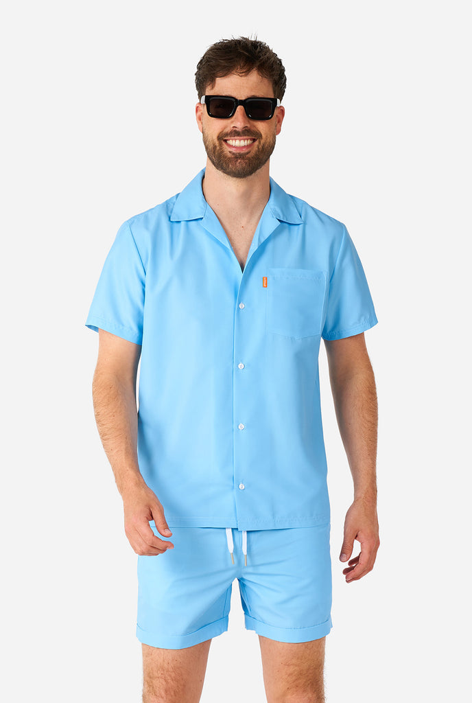 Man wearing light blue summer set, consisting of shirt and shorts