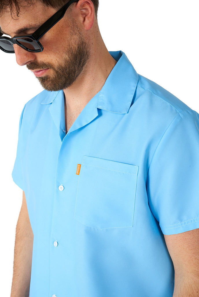Man wearing light blue summer set, consisting of shirt and shorts. Zoom in on shirt