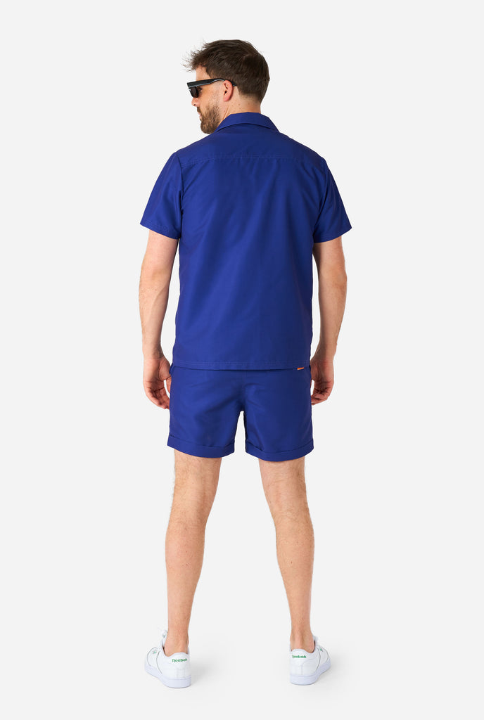 Man wearing dark blue summer set, consisting of shirt and shorts. View from the back