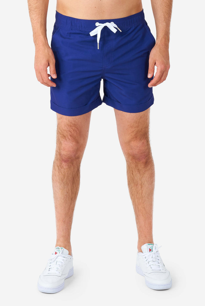 Man wearing dark blue summer set, consisting of shirt and shorts. Zoomed in at shorts