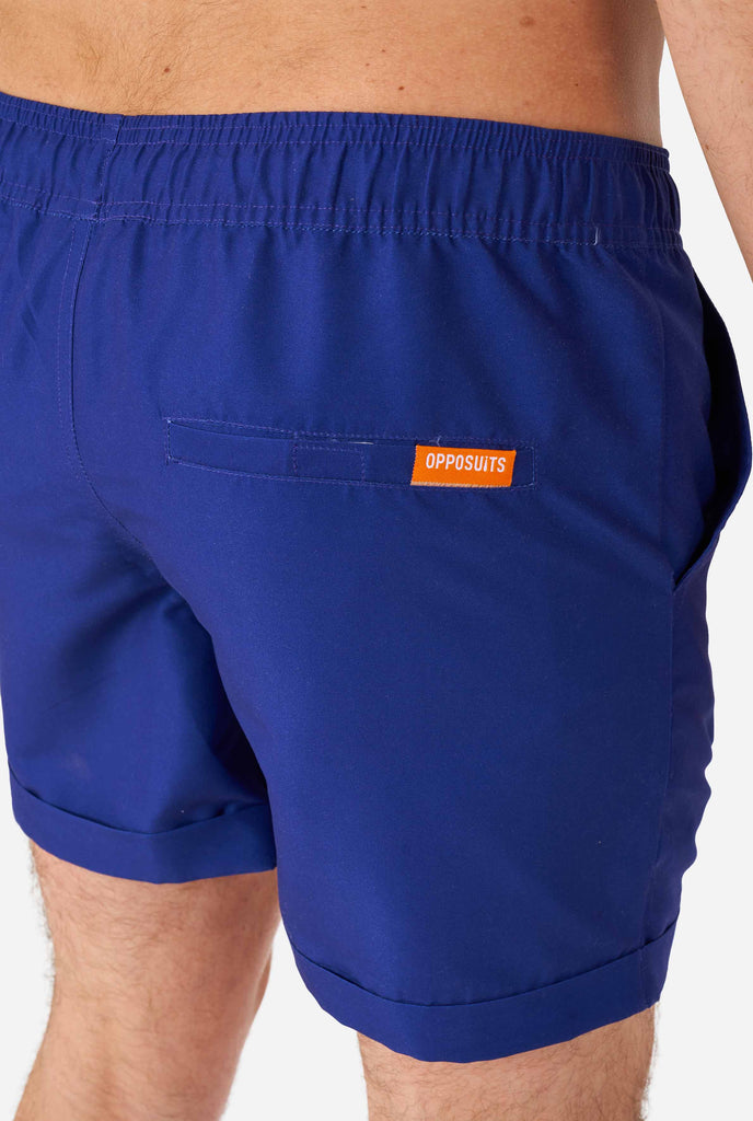 Man wearing dark blue summer set, consisting of shirt and shorts. Zoomed in on shorts
