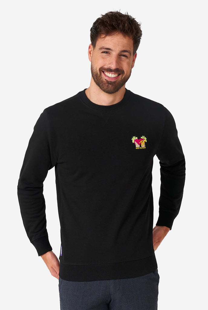 Man wearing black sweater with MTV embroidery.