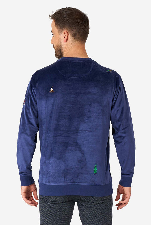 Man wearing velvet blue Christmas sweater with Christmas icons