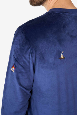 Man wearing velvet blue Christmas sweater with Christmas icons