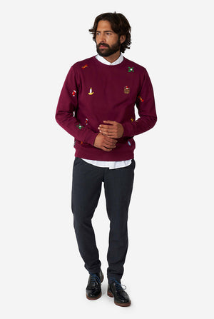 Man wearing burgundy red Christmas sweater with Christmas icons