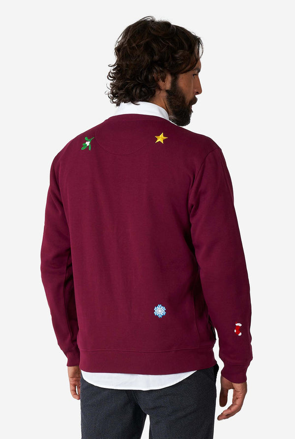 Man wearing burgundy red Christmas sweater with Christmas icons