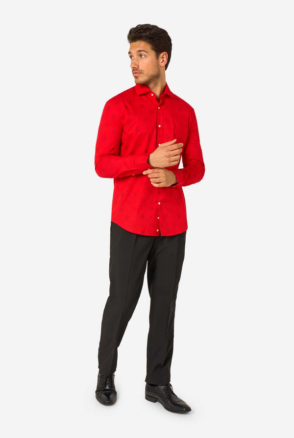 Man wearing red dress shirt with black outlined Christmas icons and black pants. Full body image.