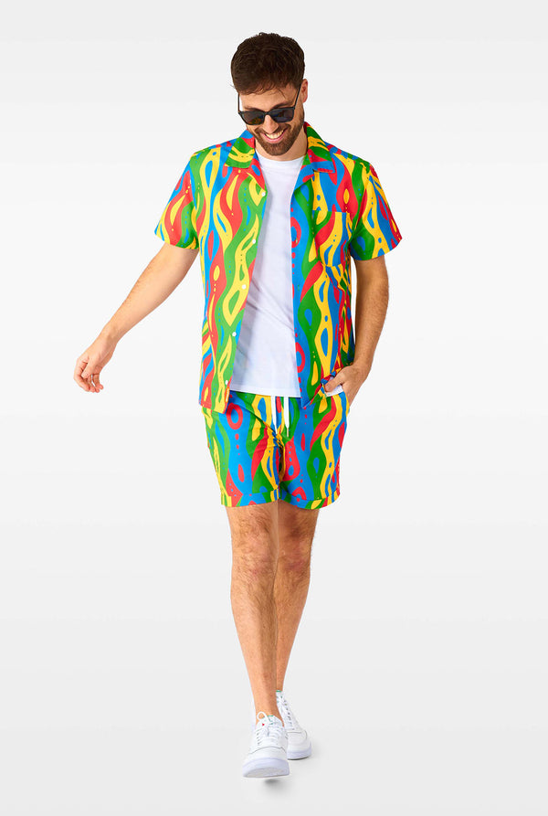 Man wearing colorful summer set, consisting of shirt and shorts.