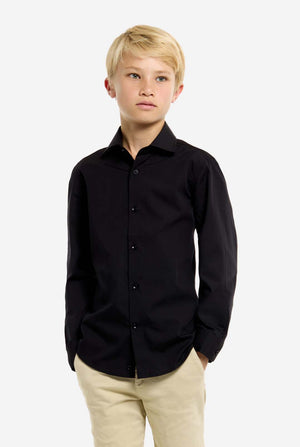 Person wearing a black shirt and beige pants on a white background