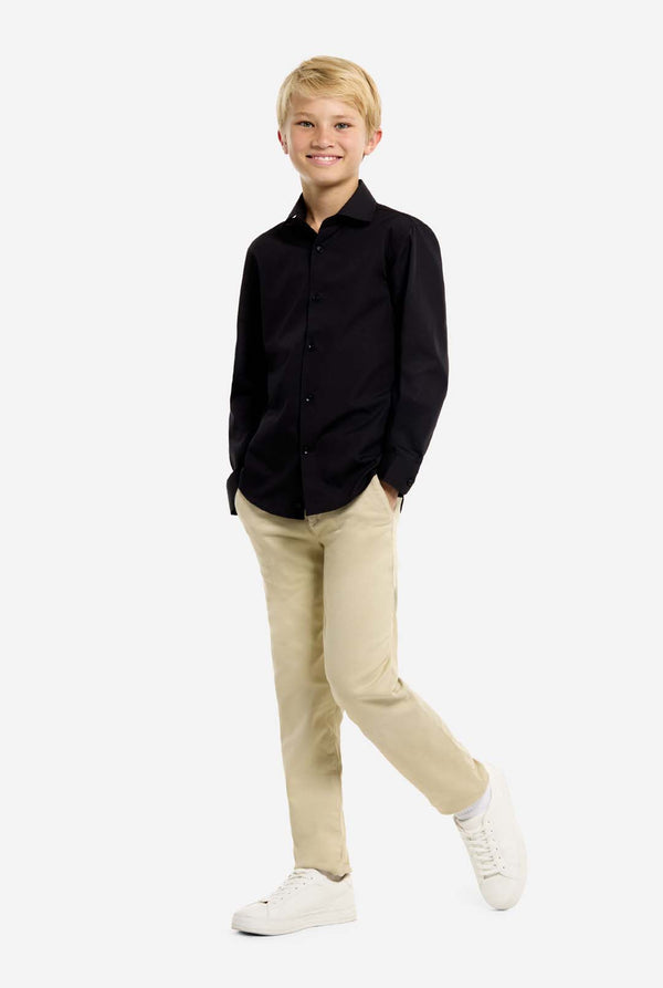 Person wearing a black shirt, beige pants, and white shoes on a white background