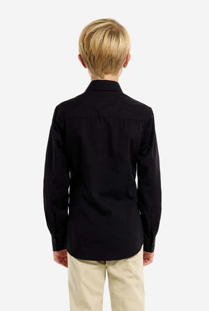 Person wearing a black shirt and beige pants on a white background