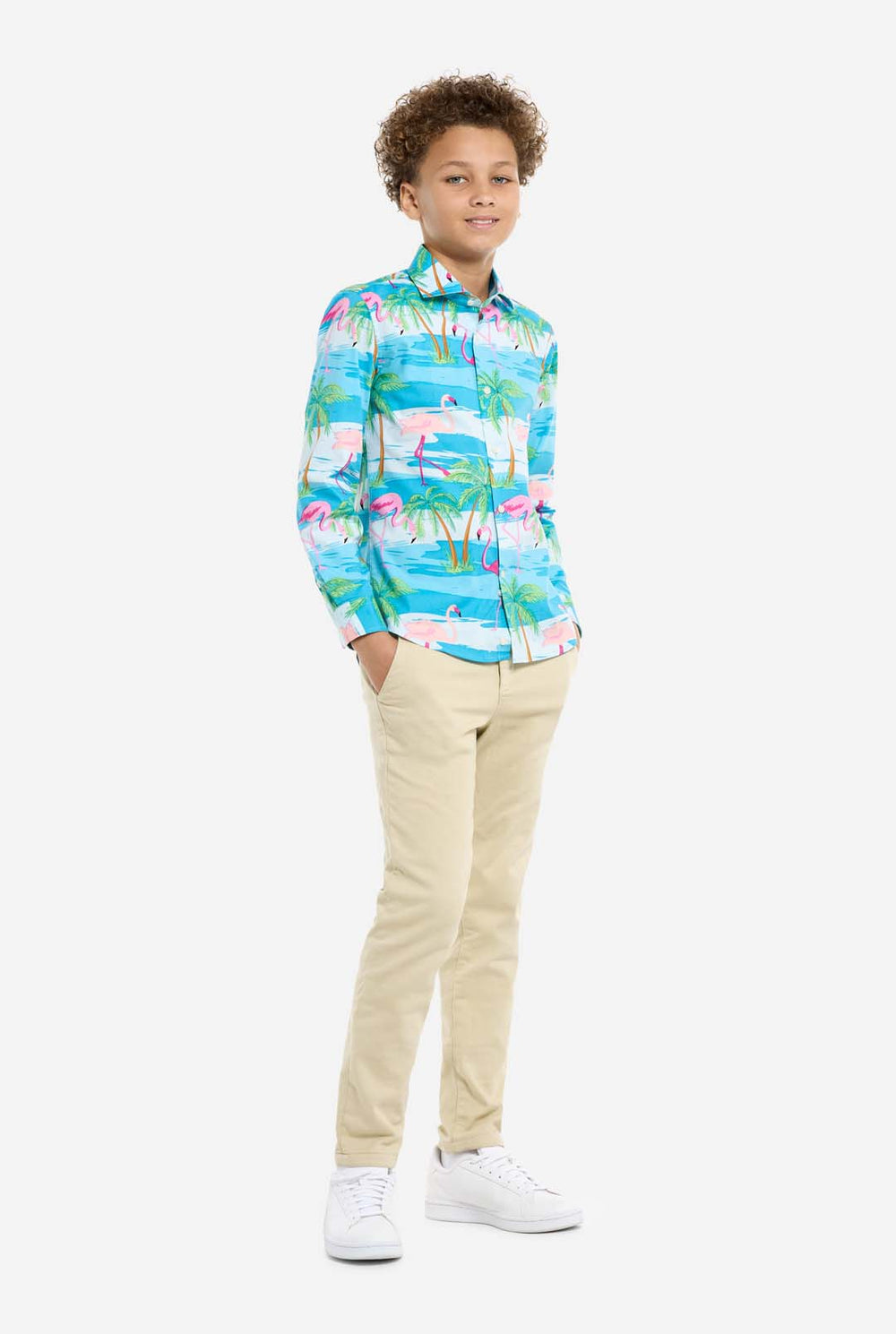 Child wearing a colorful shirt with flamingo and palm tree pattern on a white background