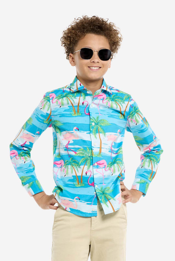 Child wearing a colorful flamingo shirt and sunglasses on a white background