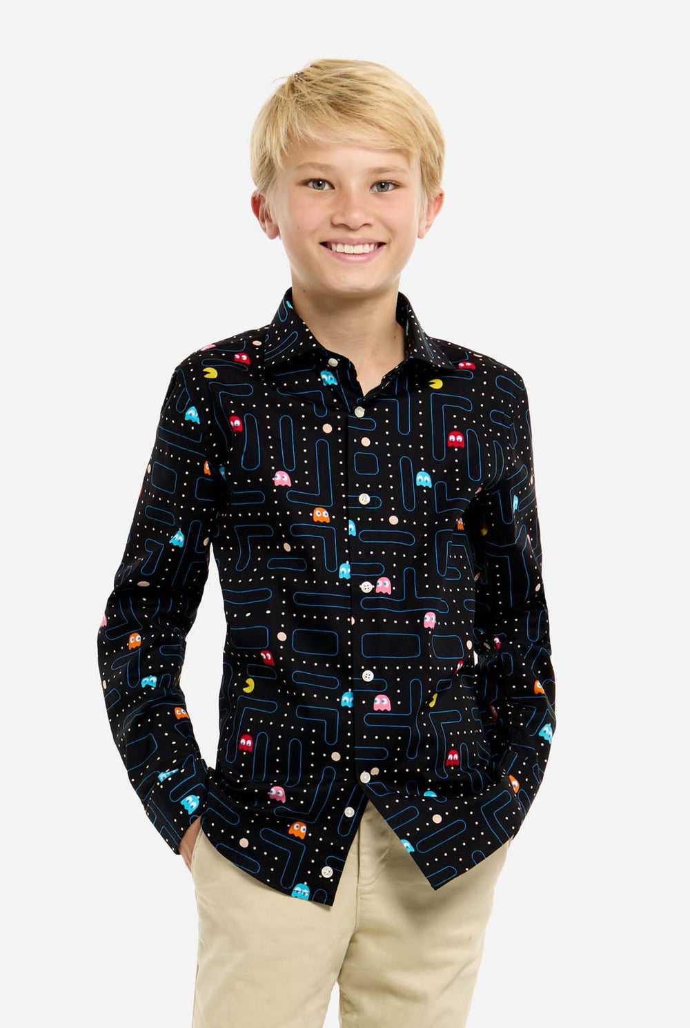 Young boy wearing a black shirt with colorful Pac-Man pattern on a white background
