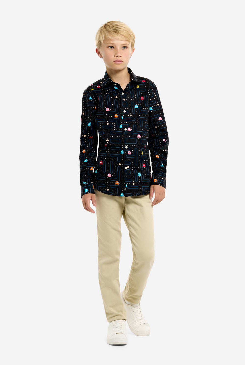 Young boy wearing a black shirt with colorful Pac-Man pattern on a white background
