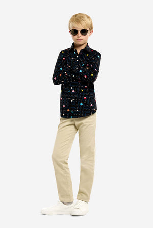 Person wearing a black patterned shirt and beige pants on a white background