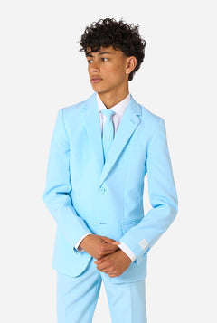 Teen wearing a light blue suit with a white shirt and tie on a light background.