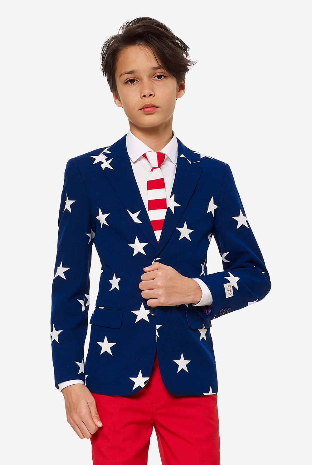 Teen wearing formal USA themed fourth of July suit, consisting of blue jacket and red pants. 