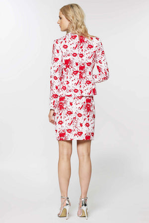 Woman wearing white suit with red blood spatters