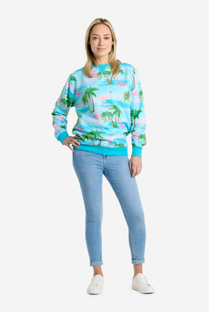 Person wearing a colorful tropical-themed sweatshirt and light blue jeans on a white background