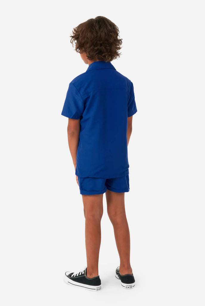 Boy wearing dark blue summer set, consisting of shorts and shirt, view from the back