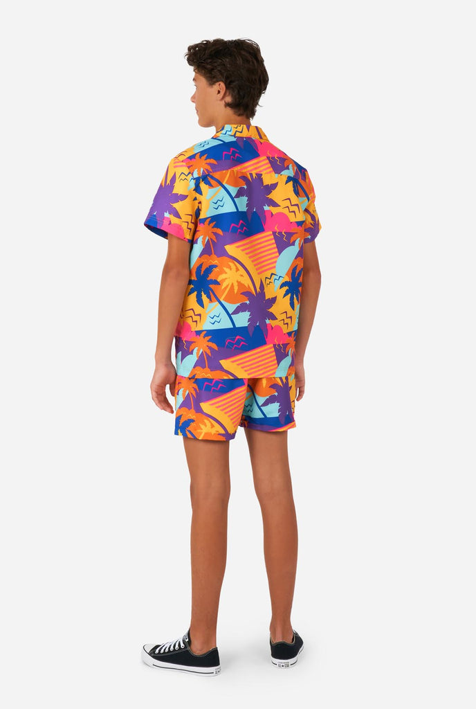 Teen wearing colorful palm summer set, consisting of shirt and short., view from the back