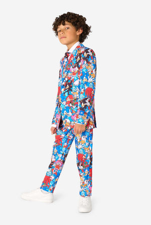 Young boy wearing a vibrant Sonic teen suit featuring colorful prints of Sonic the Hedgehog characters including Sonic, Knuckles, Tails, and Amy, paired with a matching tie and white shirt. Full body, one foot forward.