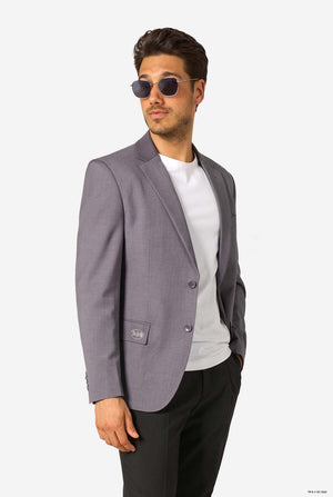 Man wearing a gray blazer, white shirt, and sunglasses on a grey background