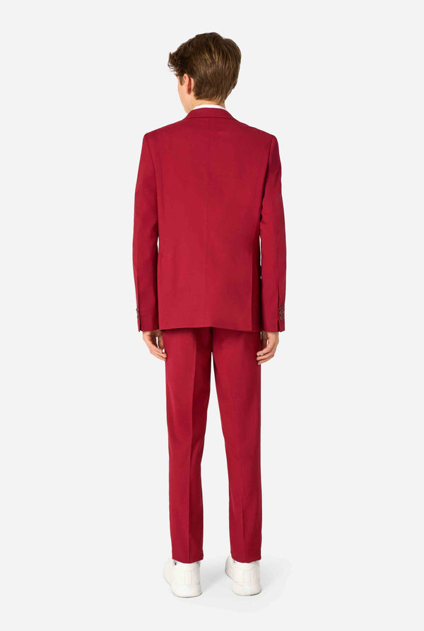 Teen boy wearing a stylish burgundy red suit with a white dress shirt, looking confidently. Perfect formal outfit for boys' special occasions, weddings, and parties. View from the back.