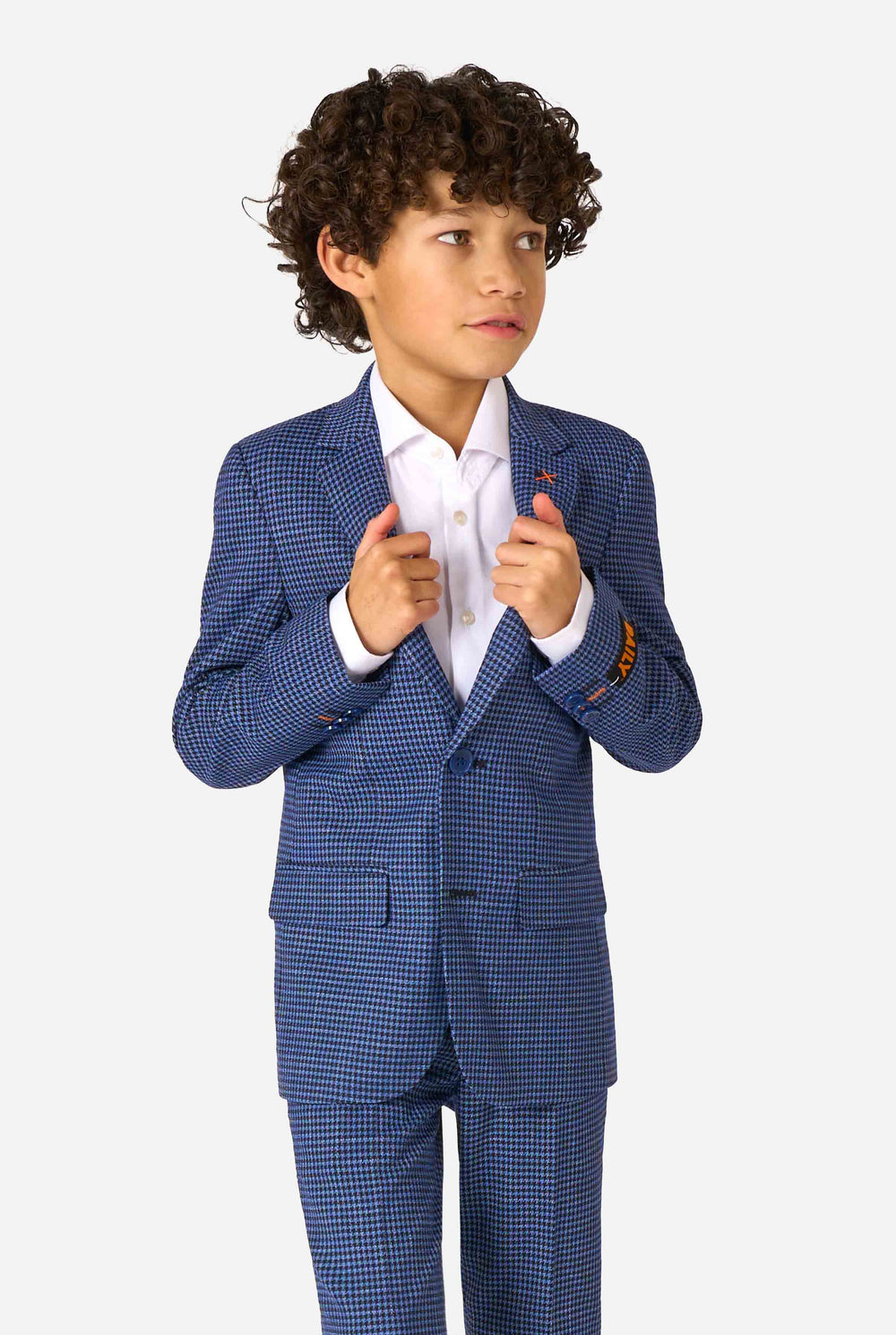 A boy wearing a navy and blue checkered suit with a white dress shirt. The suit has a modern fit with two buttons and flap pockets. He stands against a plain white background.
